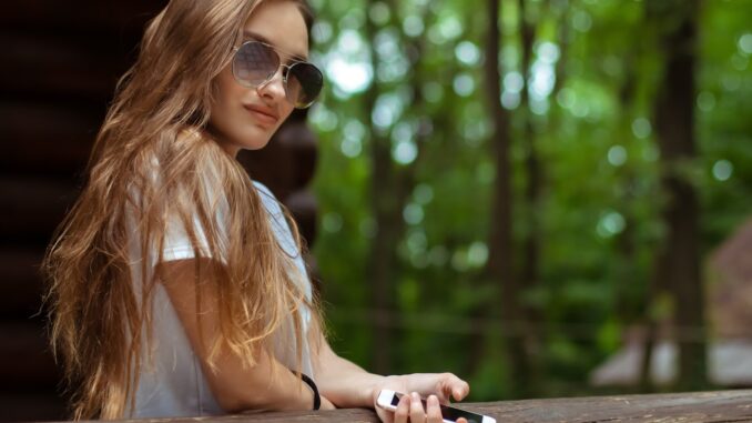 sexy girl in sunglasses at the wooden house posing