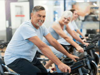 Confident seniors on exercise bikes in spinning class at gym