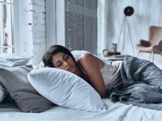 Lost in a deep sleep. Attractive young woman keeping eyes closed while lying on the bed at home