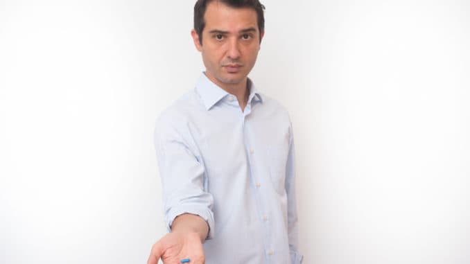 Man showing a bunch of medicine pills in his hand