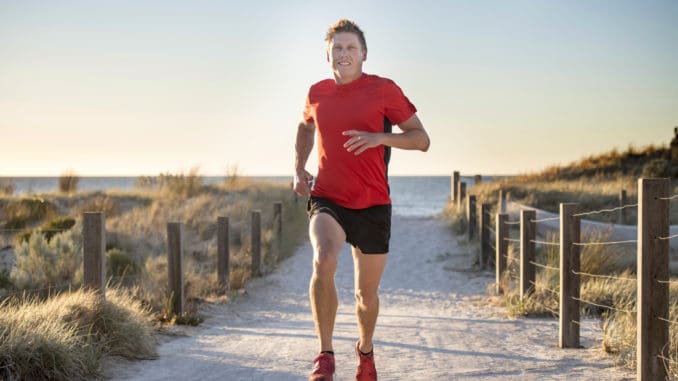 dreamstime_m_108925266 Young attractive and happy sport runner man with fit and strong healthy body training on off road track in Summer running workout under Summer sun in health care and competition concept