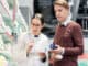 Low-angle view of a handsome young men holding two prescribed medicines while looking at various pharmaceutical products in a modern drugstore with helpful pharmacists