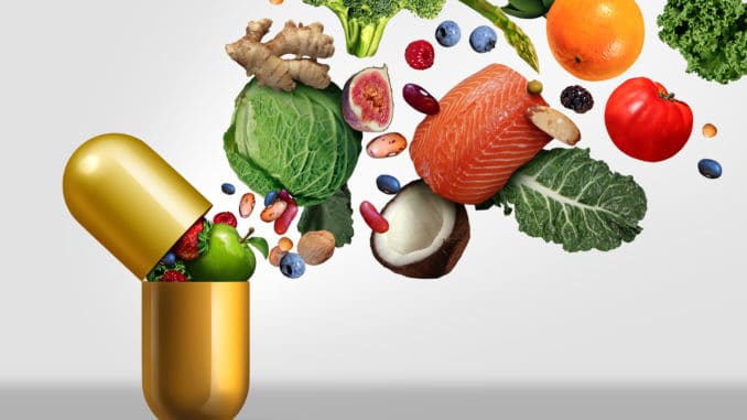 Vitamins supplements as a capsule with fruit vegetables nuts and beans inside a nutrient pill as a natural medicine health treatment