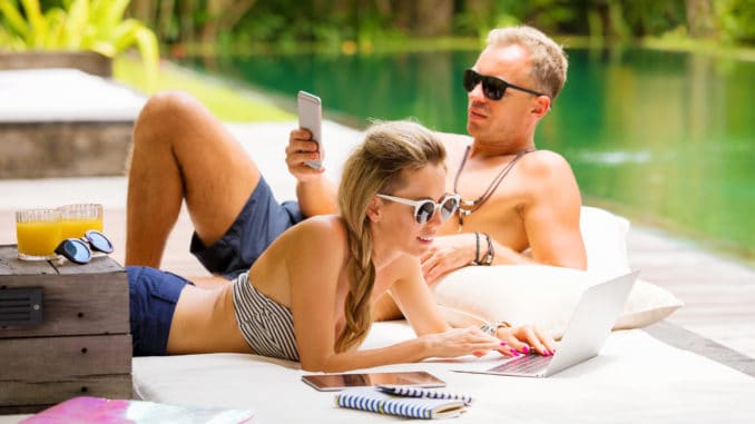 Stress free couple relaxing in hot summer day and using tech