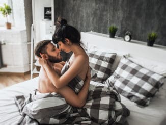 Man and woman making love in bed