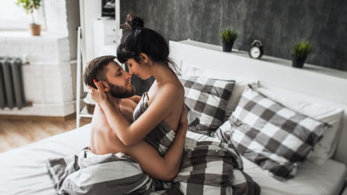 Man and woman making love in bed