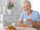 Portrait of smiling senior man drinking tea at home