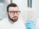 Male laboratory assistant working with bacteria in petri dish in the bacteriological department