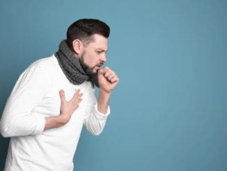 Mature man coughing on color background