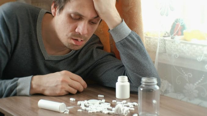 dreamstime_m_115328808 Man has a lot of pills and falls asleep