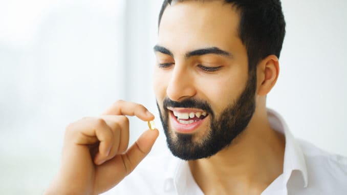 Beautiful Man Taking Pill, Medicine. Vitamins And Supplements.