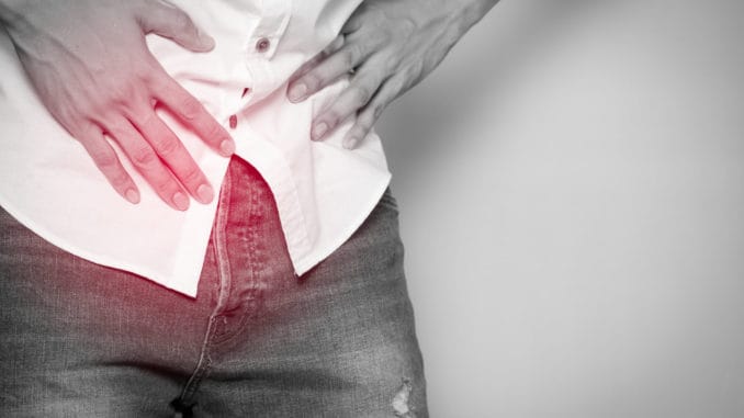 Male hands holding on middle crotch of trousers with prostate inflammation, Prostate cancer, Men`s health care concept.