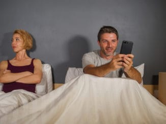 boyfriend using mobile phone in bed