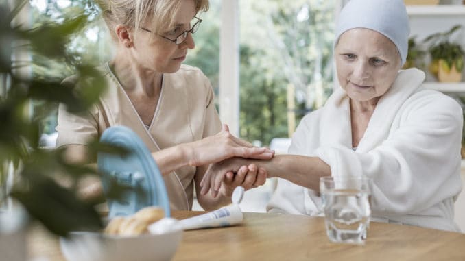 Nurse helping sick elderly women with cancer during treatment at home concept