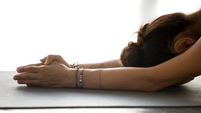 dreamstime_m_127405775 Young attractive woman practicing yoga, doing meditation exercise, relaxation pose, working out, indoor close up, at yoga studio, side view. Healthy hobby wellbeing activity concept