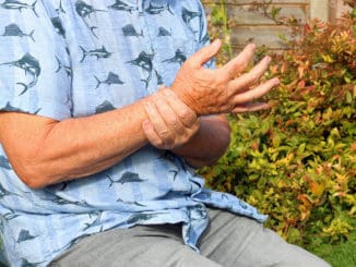 Elderly or senior man holding his wrist because of pains. Arthritis in his joints.