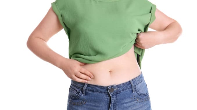 Overweight woman touching belly fat before weight loss on white background Overweight woman touching belly fat before weight loss