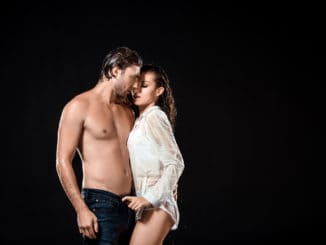 couple with wet hair posing isolated on black
