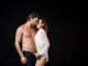 couple with wet hair posing isolated on black