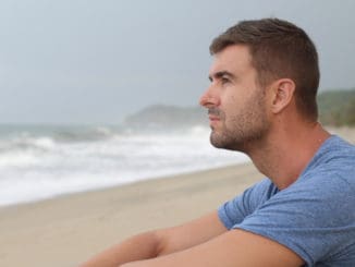 Man thinking at the beach with copy space.