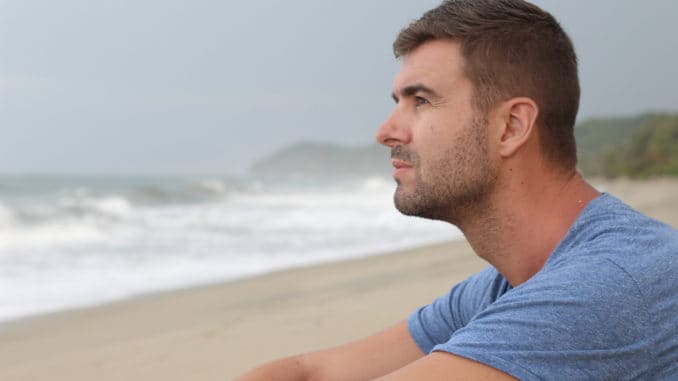 Man thinking at the beach with copy space.