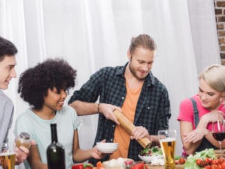 man adding spice to food with pepper grinder