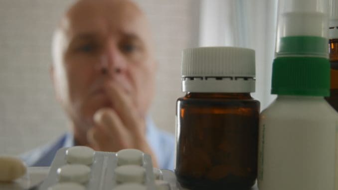 Image with a Man Looking for Pills in a Pharmacy Closet.