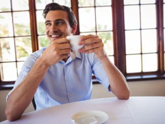 Smiling man having coffee in restaurant