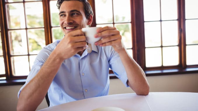 Smiling man having coffee in restaurant