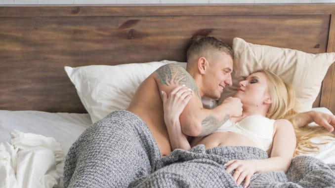 dreamstime_m_136589115 Happy couple flirting and speaking in the morning on a comfortable bed at home or hotel room.