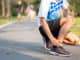 Young fitness man holding his sports leg injury.