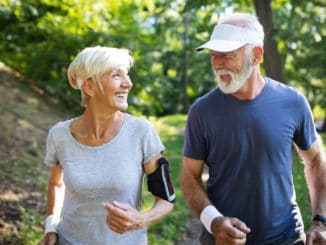 Healthy mature couple jogging in a park at early morning