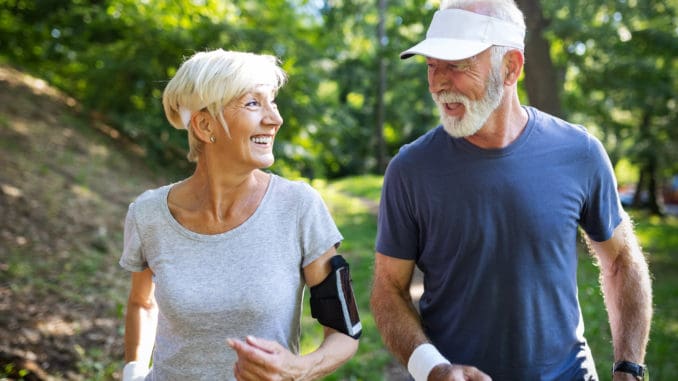 Healthy mature couple jogging in a park at early morning