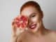 Beauty woman with orange pomegranate cut in half over white background. Attractive fresh vitamin concept