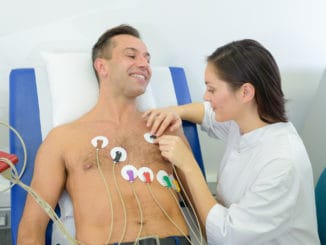 Nurse attaching heart monitor pads to patient cardio