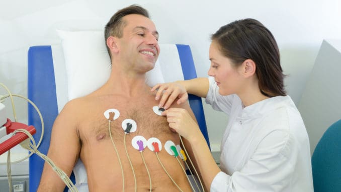 Nurse attaching heart monitor pads to patient cardio