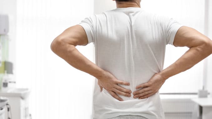 Man suffering from back pain in orthopedist s office