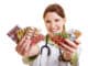 Smiling female doctor holding many colorful pills in her hands