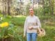 young woman with wicker basket and knife picking mushrooms in forest