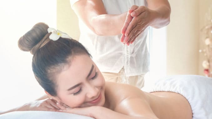 Asia beautiful women enjoying a salt scrub massage at the health spa in Thailand