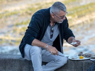 Man eating oysters bought on the seafront at Cancale