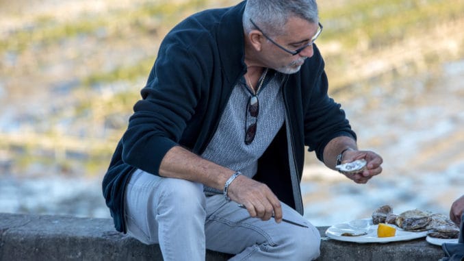 dreamstime_m_154153405 Man eating oysters bought on the seafront at Cancale