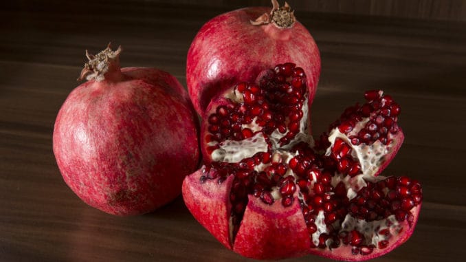 Ripe juicy pomengranate on wooden background