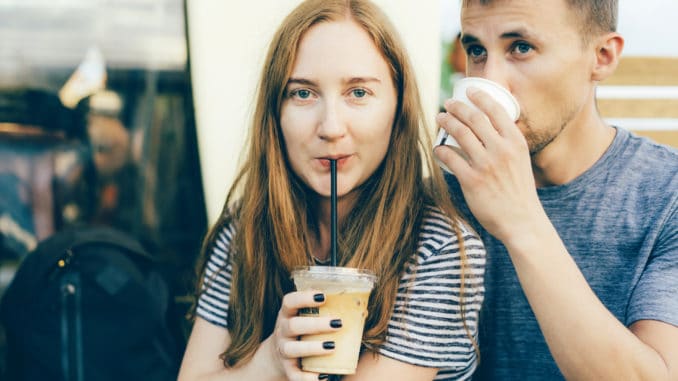 Close up portrait of a caucasian girl with a guy drinking coffee. Relations of modern millennials, coffeemania and urban style.