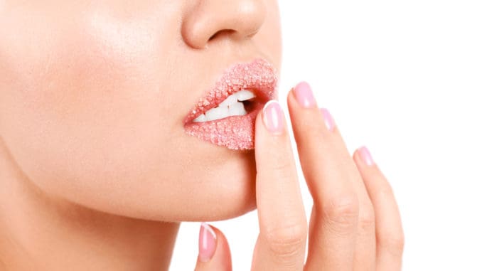 Young woman with sugar lips on white background, closeup