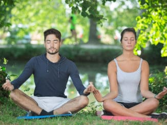Couple doing yoga in a park