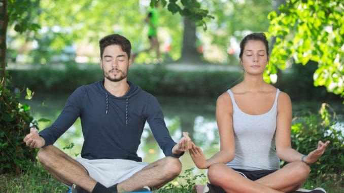 Couple doing yoga in a park