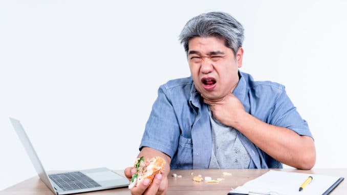 dreamstime_m_174857378 man having symptoms of food stuck in his throat Since he eats hamburgers