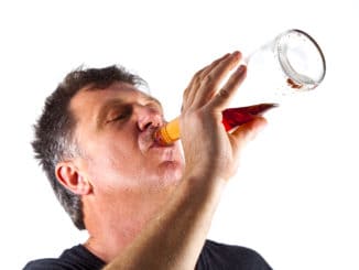 Man drinking alcohol out of a bottle