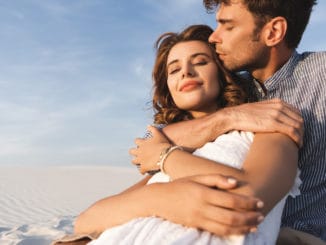 Smiling young couple hugging on beach